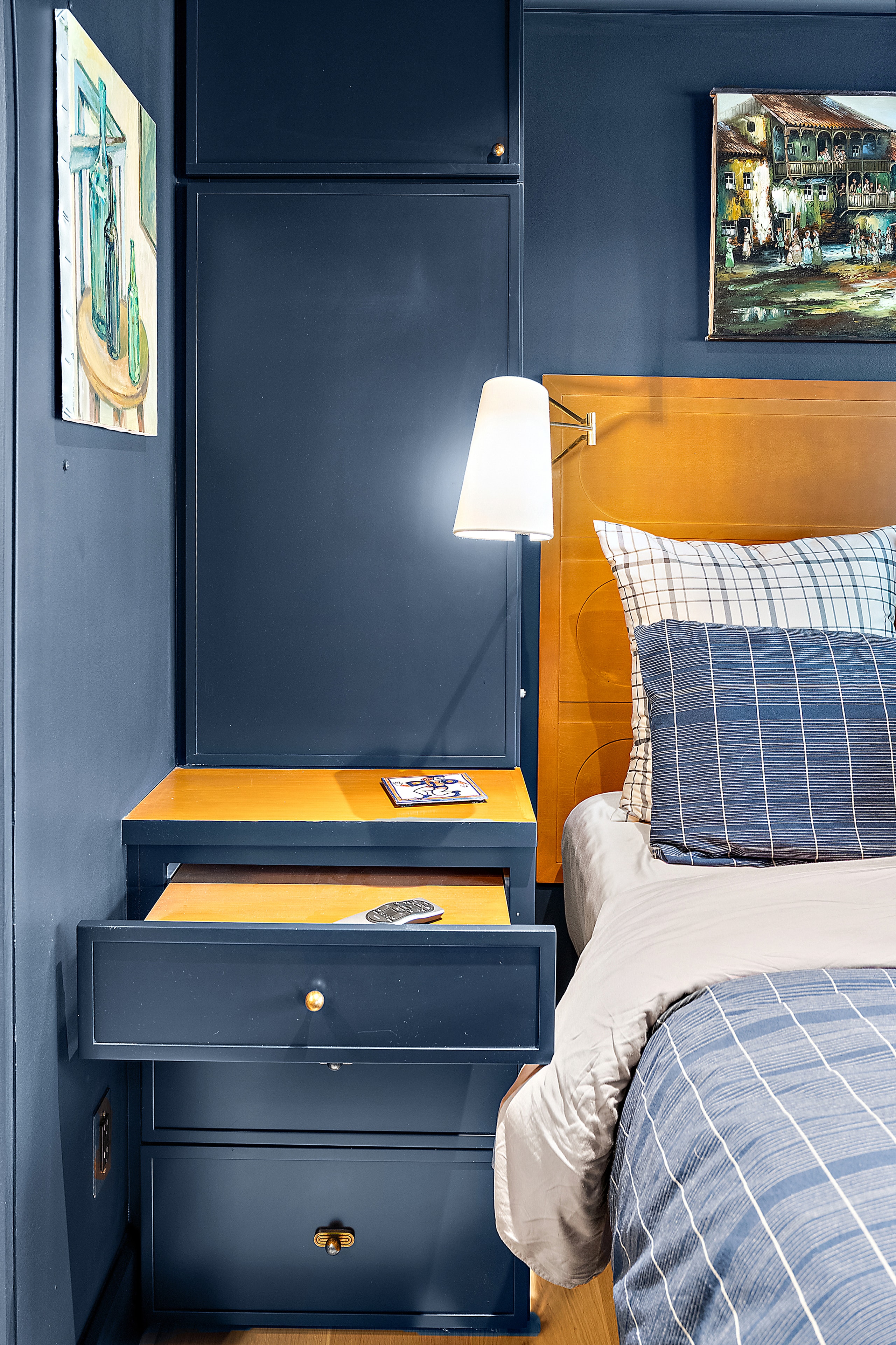 Modern bedroom with navy walls and yellow nightstand