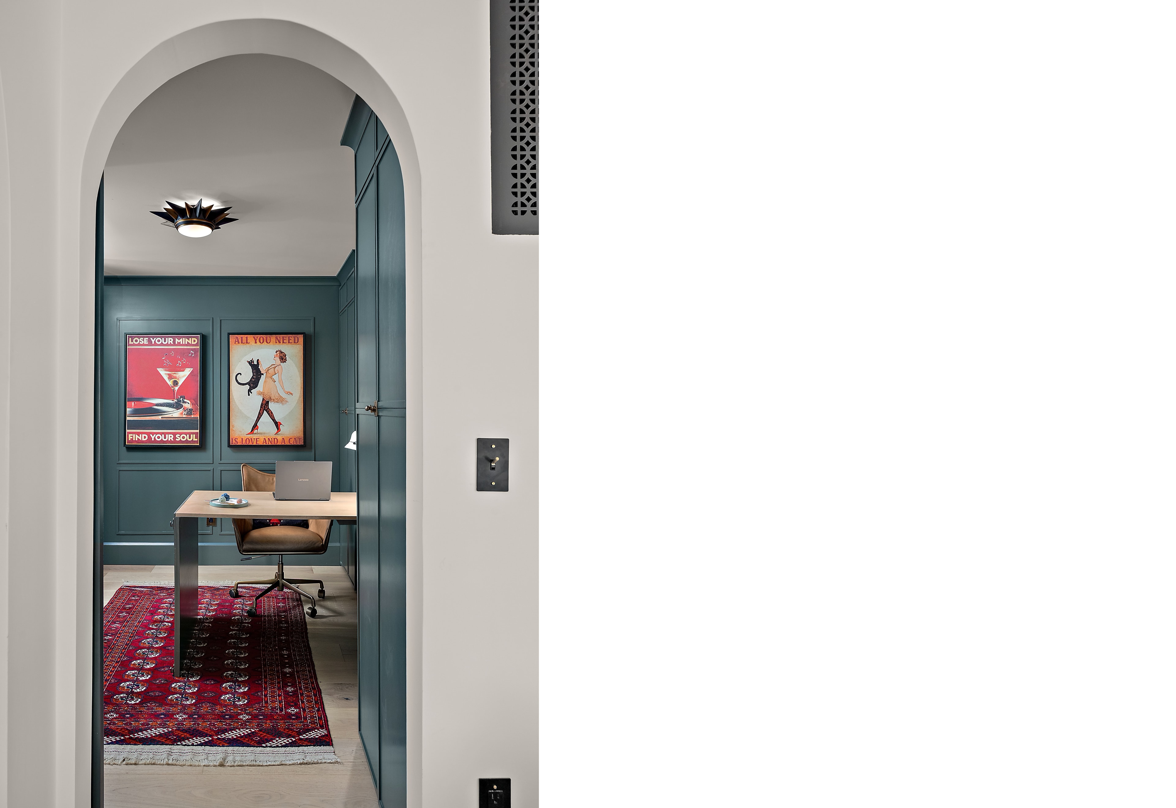 Modern home office through arched doorway