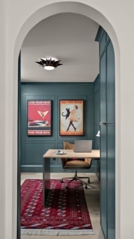 Modern home office through arched doorway