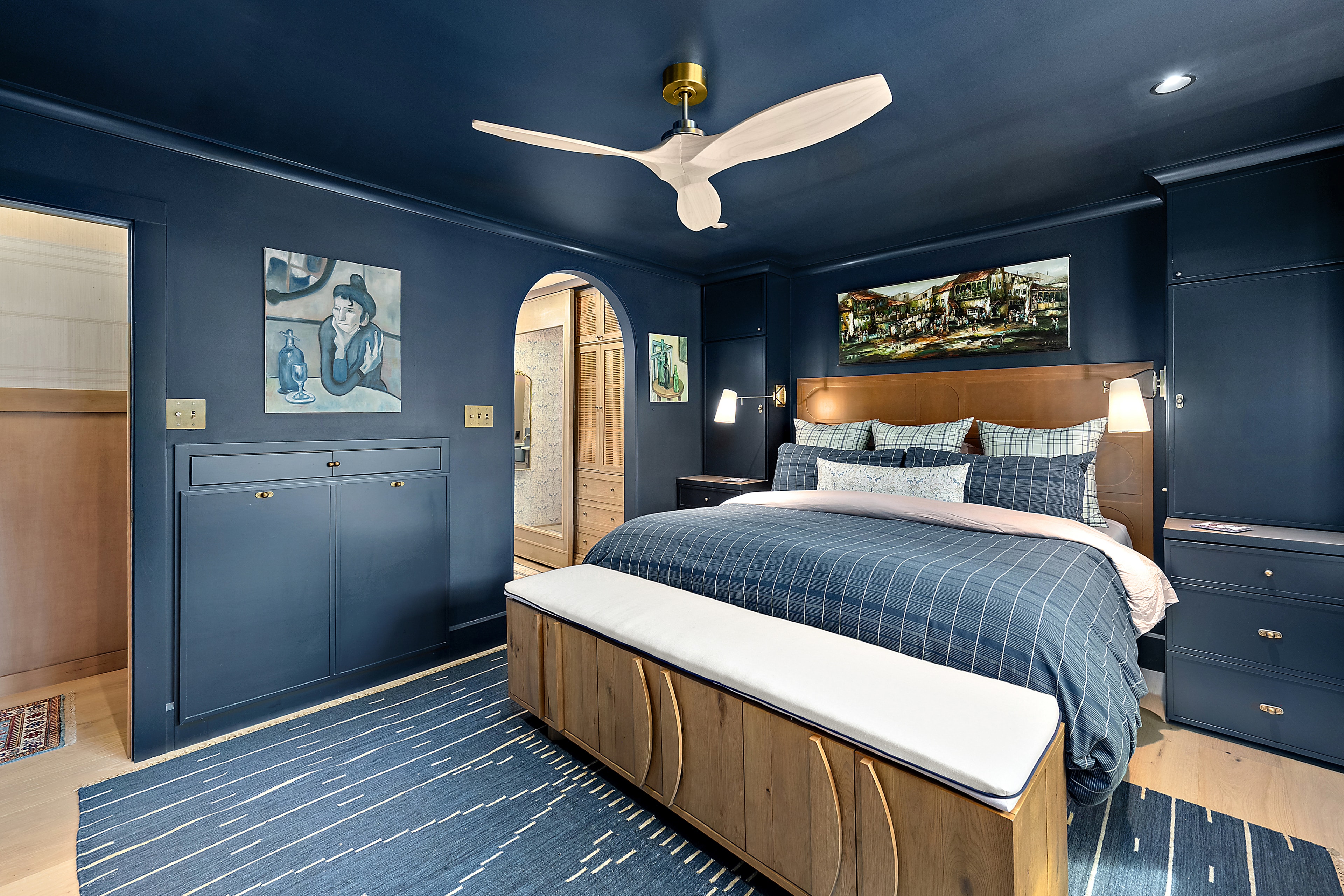 Modern bedroom with navy walls and wood furniture