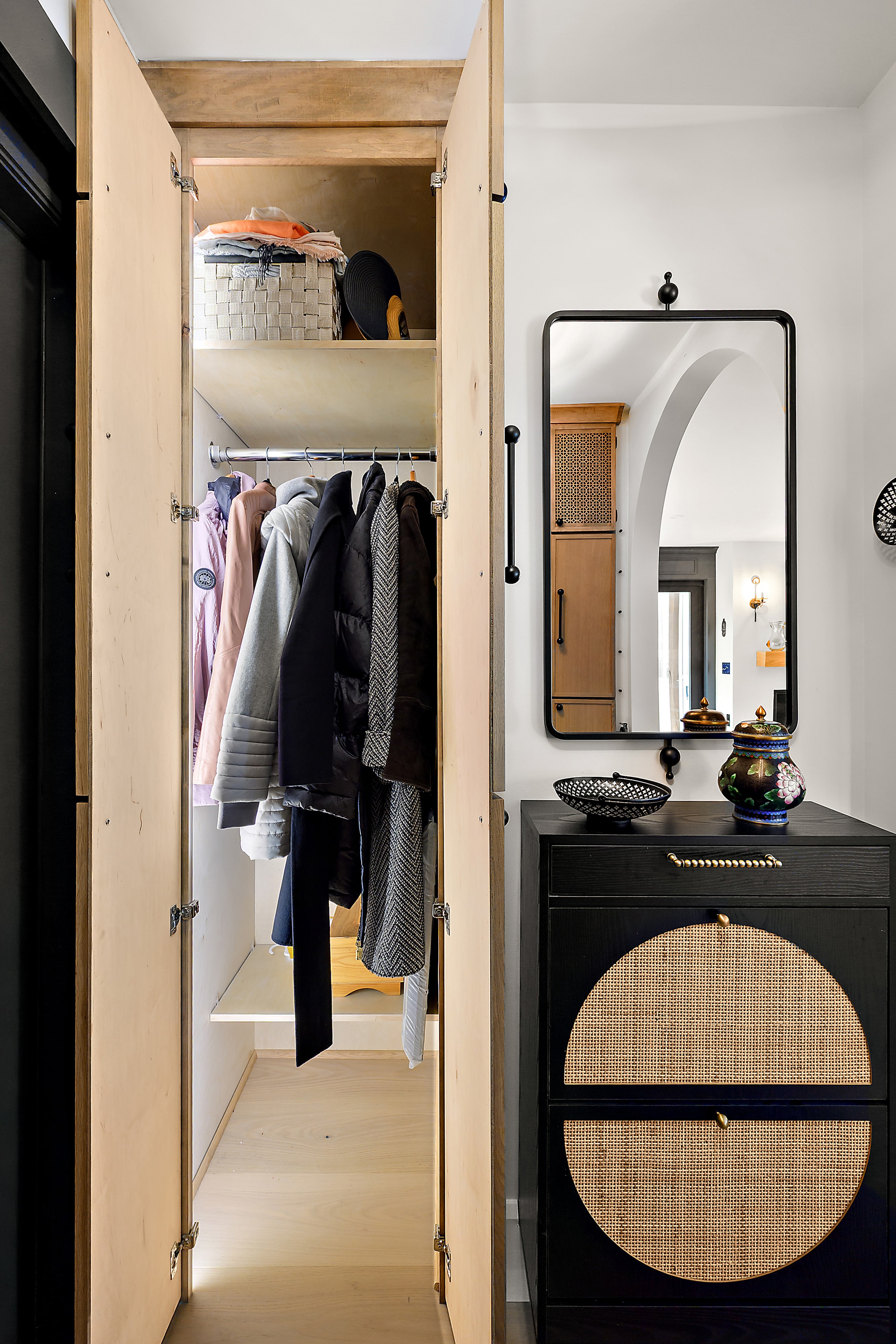 Open wooden wardrobe with hanging clothes