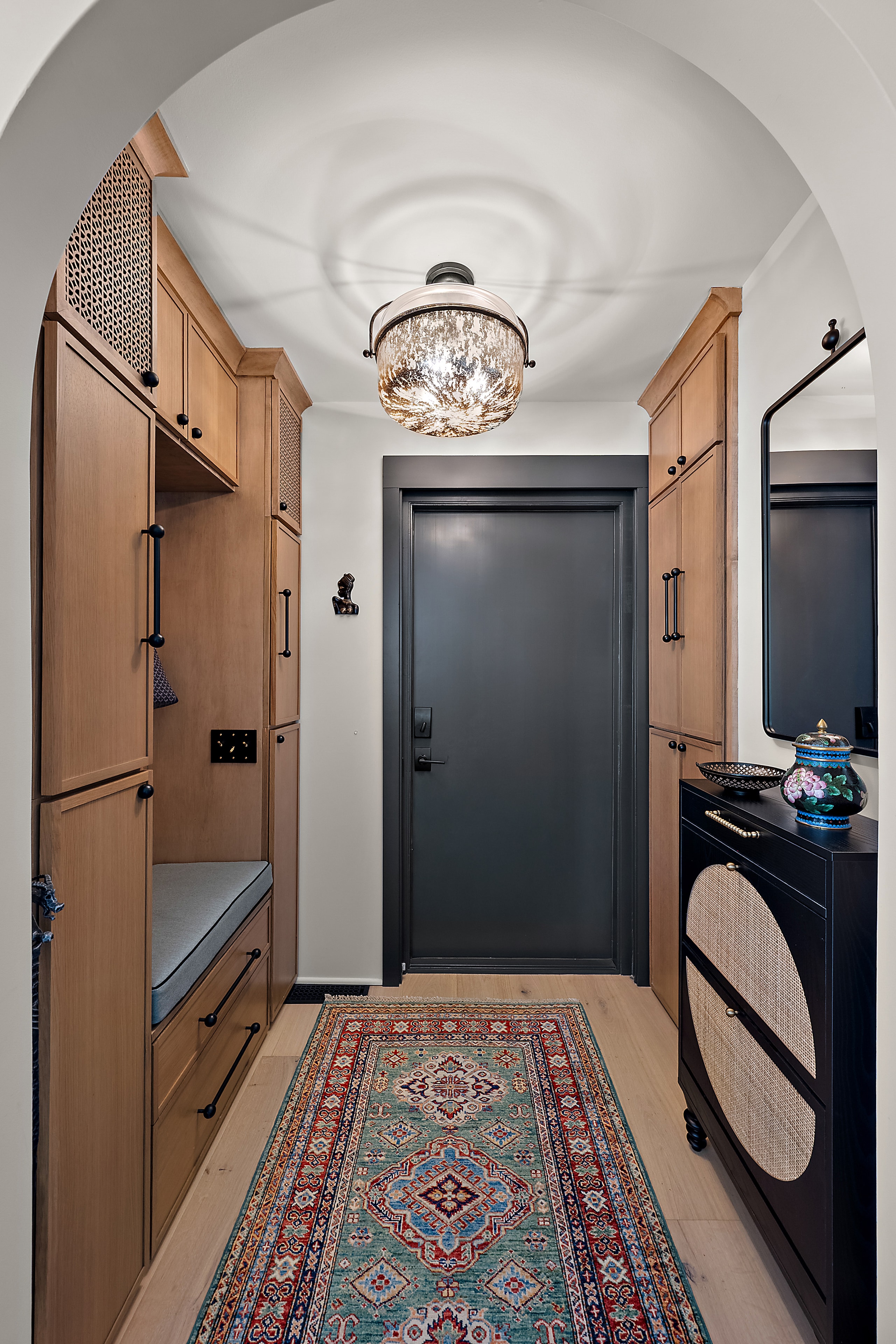 Modern hallway with arched ceiling and wood cabinetry